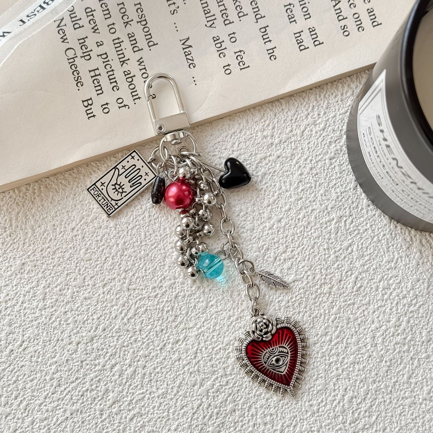 Charm keychain with red heart eye motif, fortune tarot charm, and decorative beads on metal ring